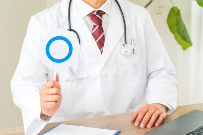 医師がカルテを持ちながら患者に説明している様子